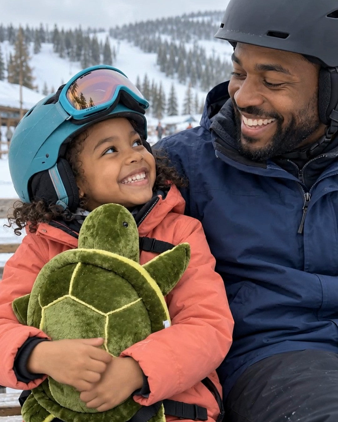 Child hugging the plush turtle pad next to her dad